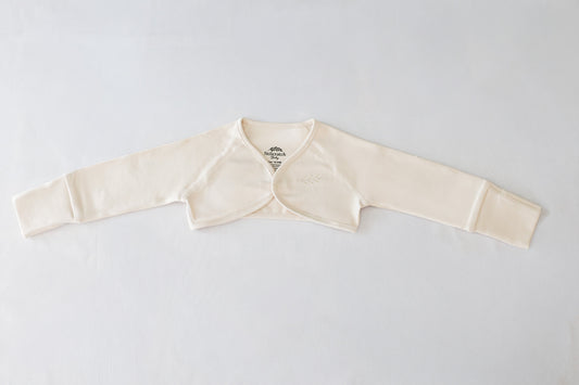 Beige anti-scratch baby sleeve shrug with fold-over mitten cuffs, flat lay