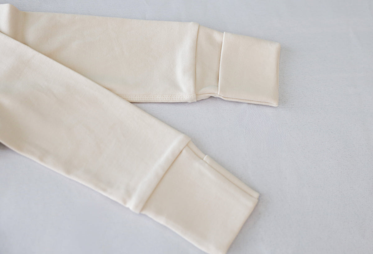Close-up of fold-over mitten cuff construction on beige sleeve